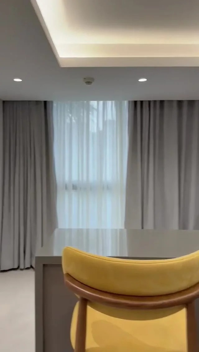 Suite 101 de The Stay : le séjour et son fauteuil jaune, image extraite de la visite vidéo
