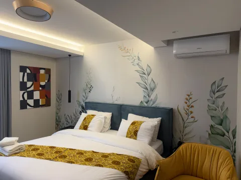 Studio 102 de The Stay : le lit double et le fauteuil jaune