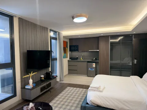 Studio 103 de The Stay : l’espace nuit avec kitchenette et téléviseur