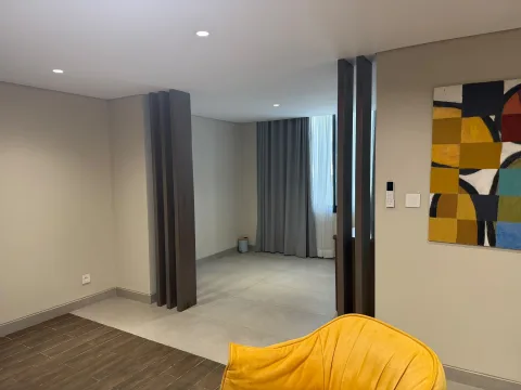 Studio 105 de The Stay : l’espace de circulation et le fauteuil jaune