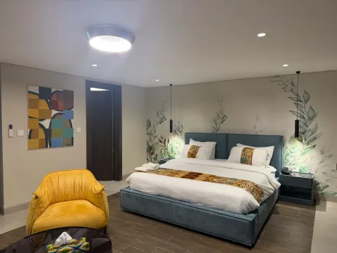 Studio 105 de The Stay : le lit double et le fauteuil jaune