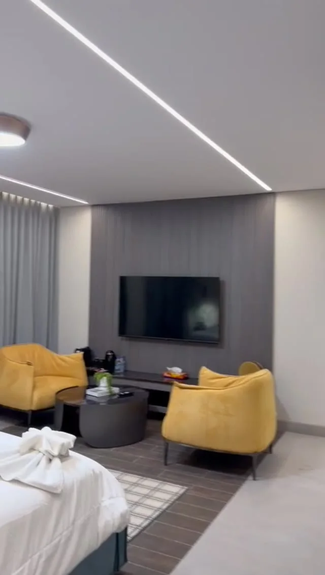 Studio 201 de The Stay : le séjour avec fauteuils jaunes et téléviseur, image extraite de la visite vidéo