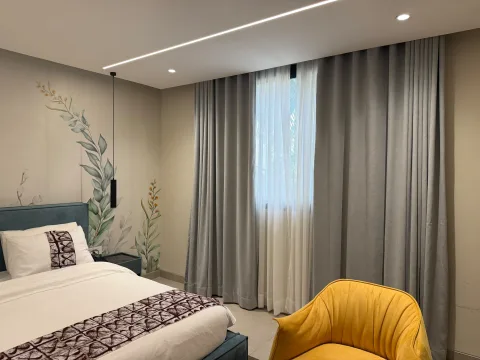 Studio 202 de The Stay : le lit et le fauteuil jaune