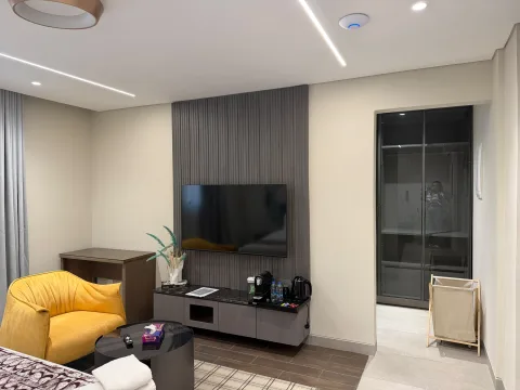 Studio 202 de The Stay : le coin télévision et le fauteuil jaune