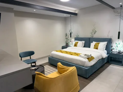 Suite 301 de The Stay : la chambre et son fauteuil jaune