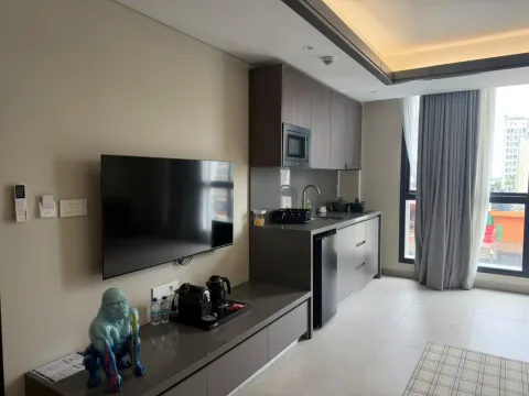 Suite 301 de The Stay : le téléviseur et la kitchenette près de la baie vitrée