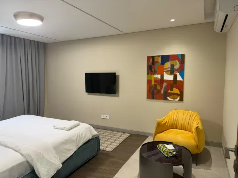 Appartement 2 pièces 305 de The Stay : la chambre avec fauteuil jaune